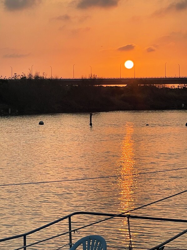 A sunset over a calm river with a bridge in the background.