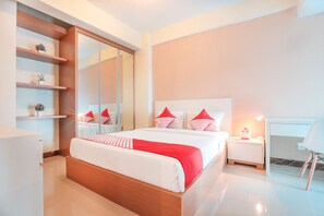 A modern bedroom with a large bed, bedside tables, a wardrobe, and a desk. - OYO Flagship 755 Appartel Grand Dhika City (Bekasi)