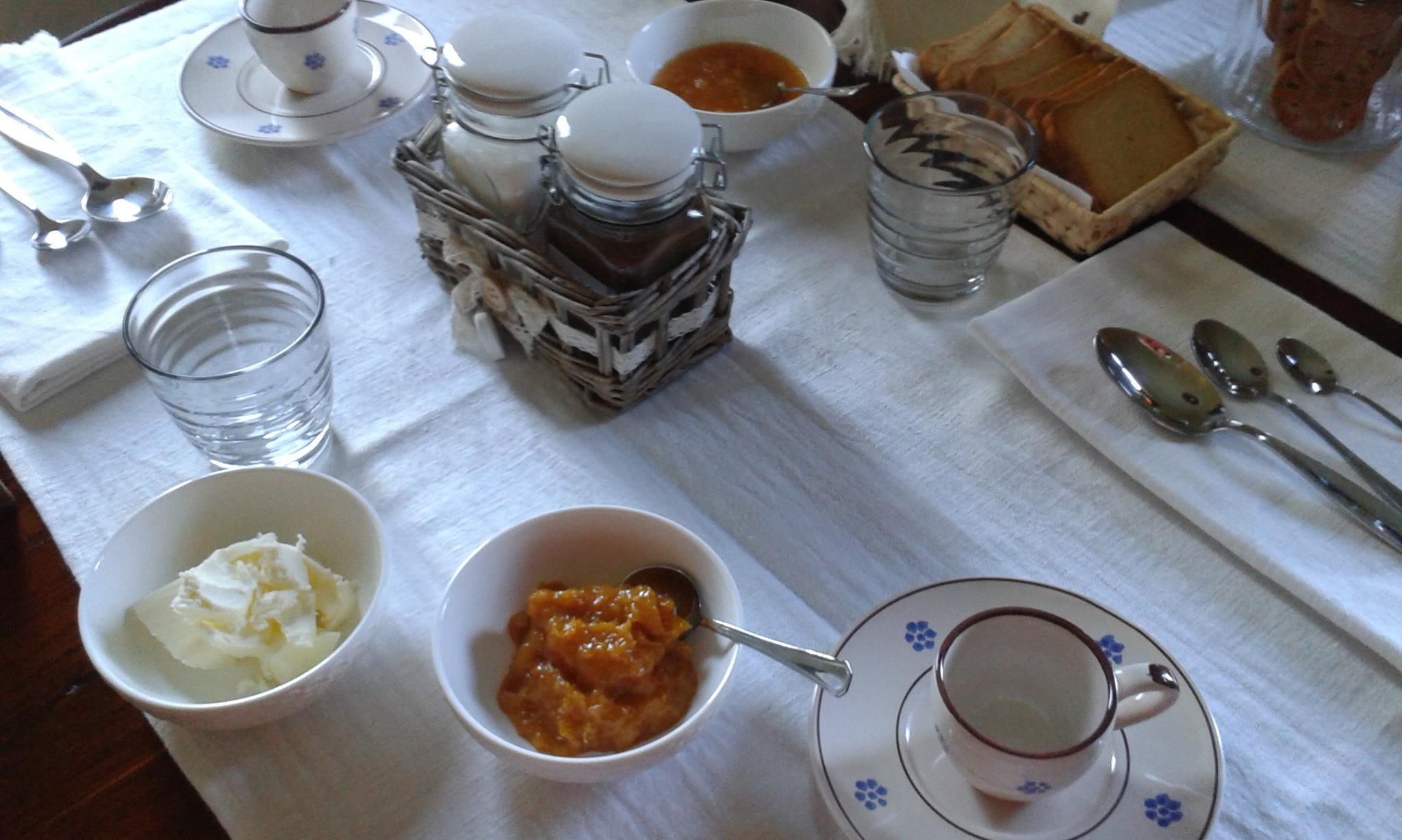 Una mesa dispuesta con diferentes platos, incluyendo un tazón de sopa, una taza de té y una fuente de pan.