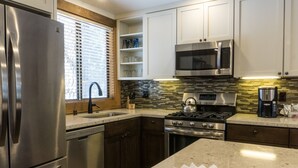 A modern kitchen with stainless steel appliances, a microwave, and a gas stove.