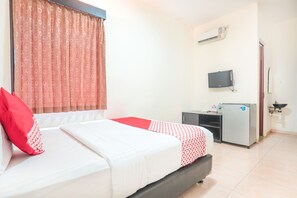 Une chambre d’hôtel équipée d’un lit, d’un bureau, d’un réfrigérateur et d’un appareil de climatisation.