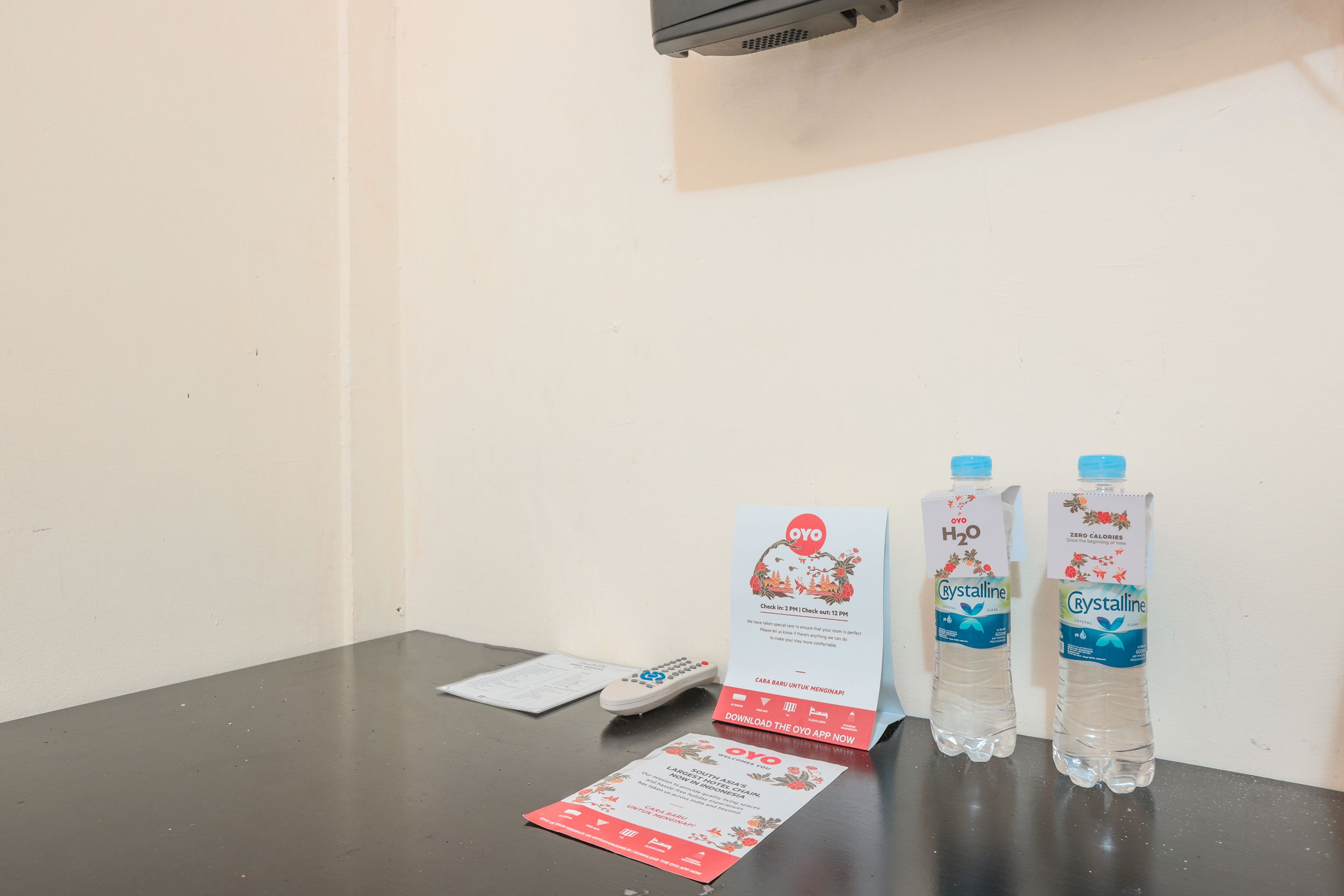 A table with two water bottles, a remote control, and a flyer.