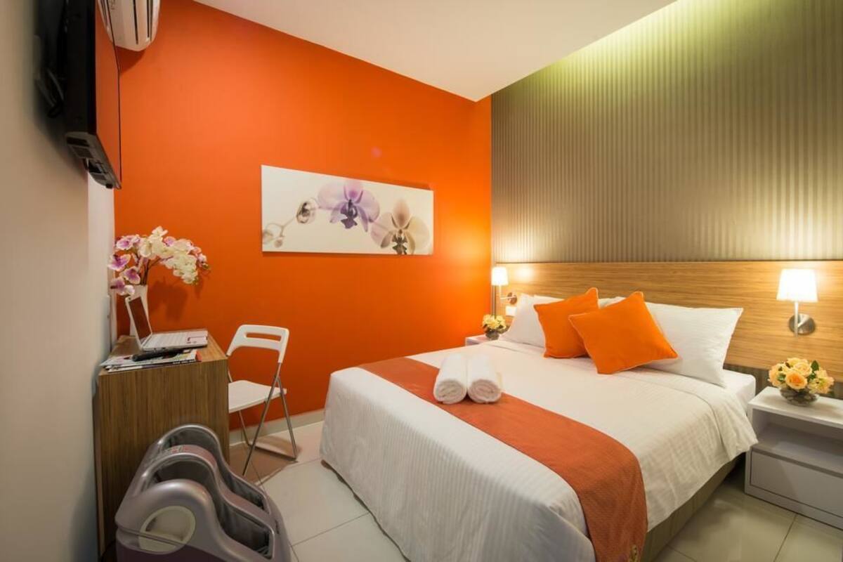 Habitació d'hotel amb llit, escriptori, cadira, televisió i butac armchair de massatge.