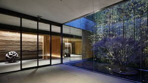 Een modern interieur met een glazen wand die een bamboebos weerspiegelt.