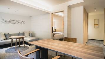A modern interior with a wooden dining table, a sofa, and a small round table.