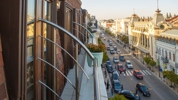 Una calle urbana con edificios a un lado y una acera al otro.
