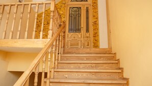 Una escalera de madera con una puerta decorativa y barandilla.