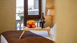 Una cama con una bandeja de fruta y vino, una lámpara y vistas al exterior.