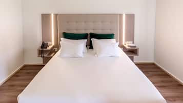 A hotel room with a large bed, two bedside tables, a telephone, and a bedside lamp.