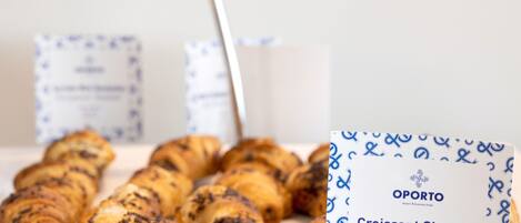 Um prato de croissants e uma caixa com a etiqueta 'Croissant Simples' da OPORTO.