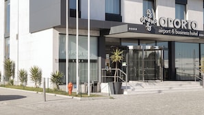 Un edificio moderno con un cartel que dice "QPORTO airport & business hotel".