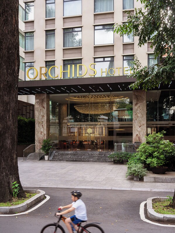 The exterior of the Orchid Hotel with a modern facade, large windows, and a prominent entrance. - Orchids Saigon Hotel (Ho Chi Minh City)
