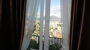 Una ventana con vista a un paisaje urbano y una montaña.