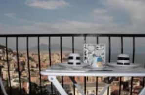 A balcony with a table and two chairs, overlooking a cityscape. - Nido Dei Gabbiani (Naples)