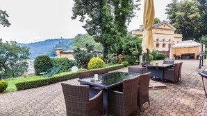 Une terrasse extérieure avec des meubles en osier, une table et une tente.
