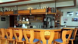 Zona de bar con sillas de madera y una barra.