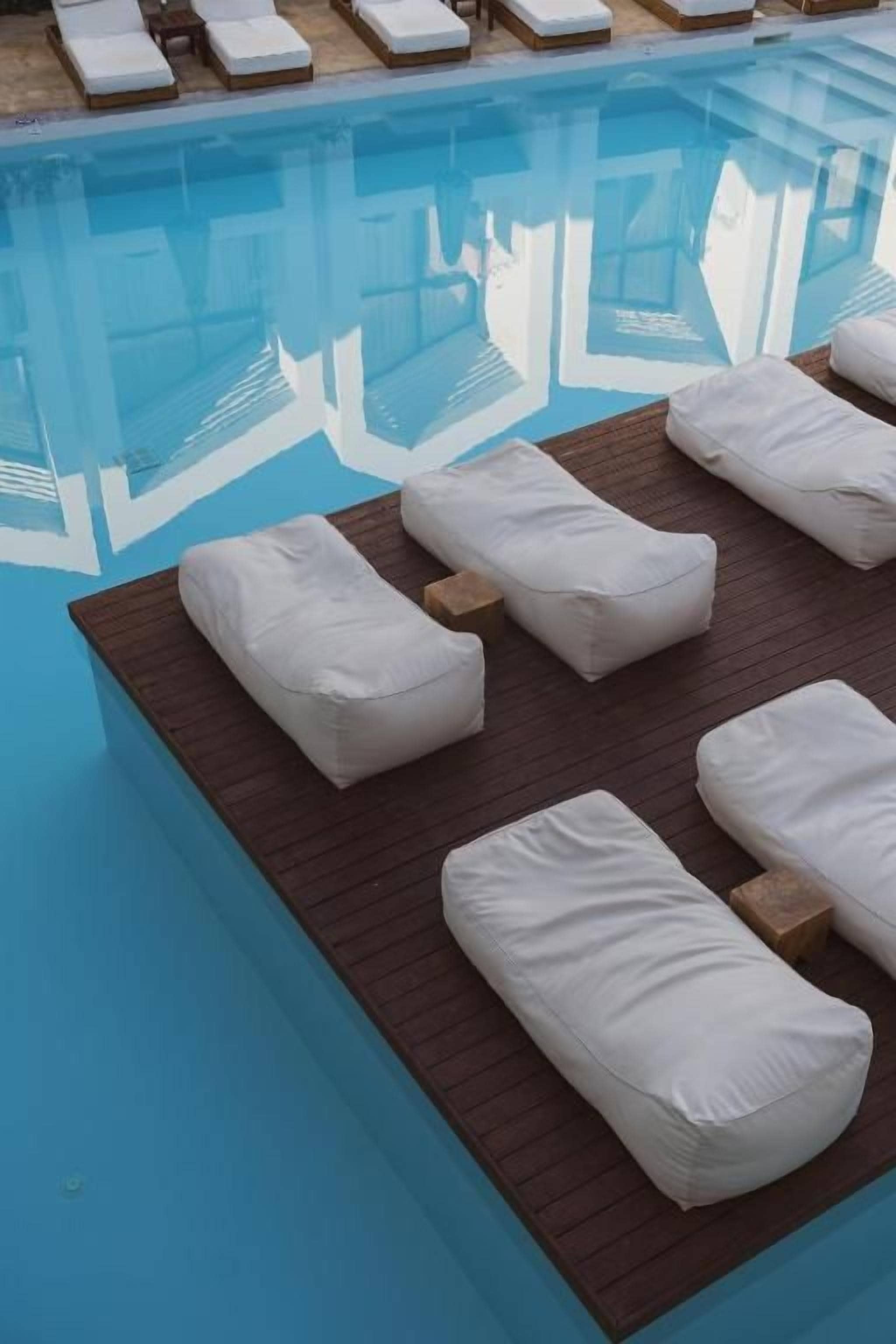 A swimming pool with lounge chairs and sun loungers.