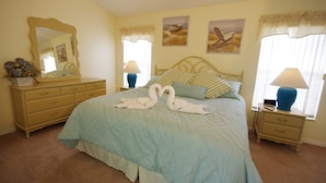A bedroom with a bed, a dresser, two bedside tables, and wall art. - Ly53807 - Indian Ridge - 3 Bed 2 Baths Villa (Kissimmee)