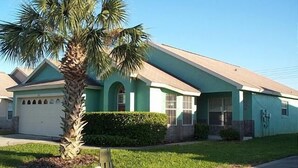 A single-story house with a sloped roof, a garage, and a well-maintained lawn. - Ly53807 - Indian Ridge - 3 Bed 2 Baths Villa (Kissimmee)