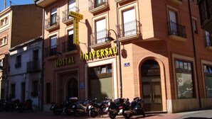 Un edificio con un letrero que dice "Hostal Universal" y un letrero que indica "Prohibido Estacionar".