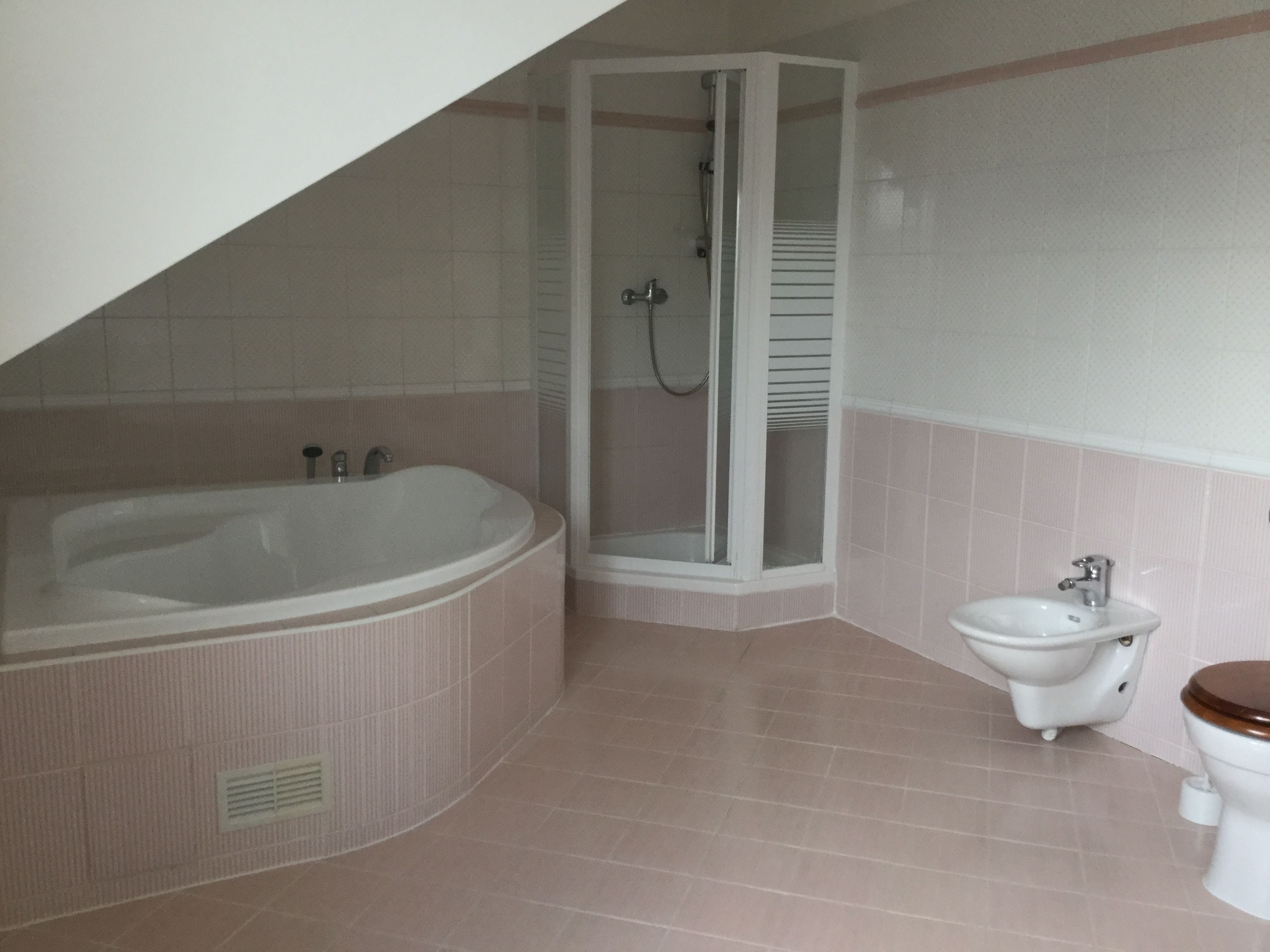 A bathroom with a bathtub, shower, toilet, and sink.