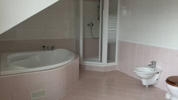 A bathroom with a bathtub, shower, toilet, and sink.