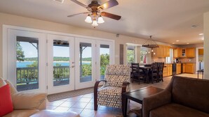 A spacious living area with a large sliding glass door leading to a balcony with a view of the sea.