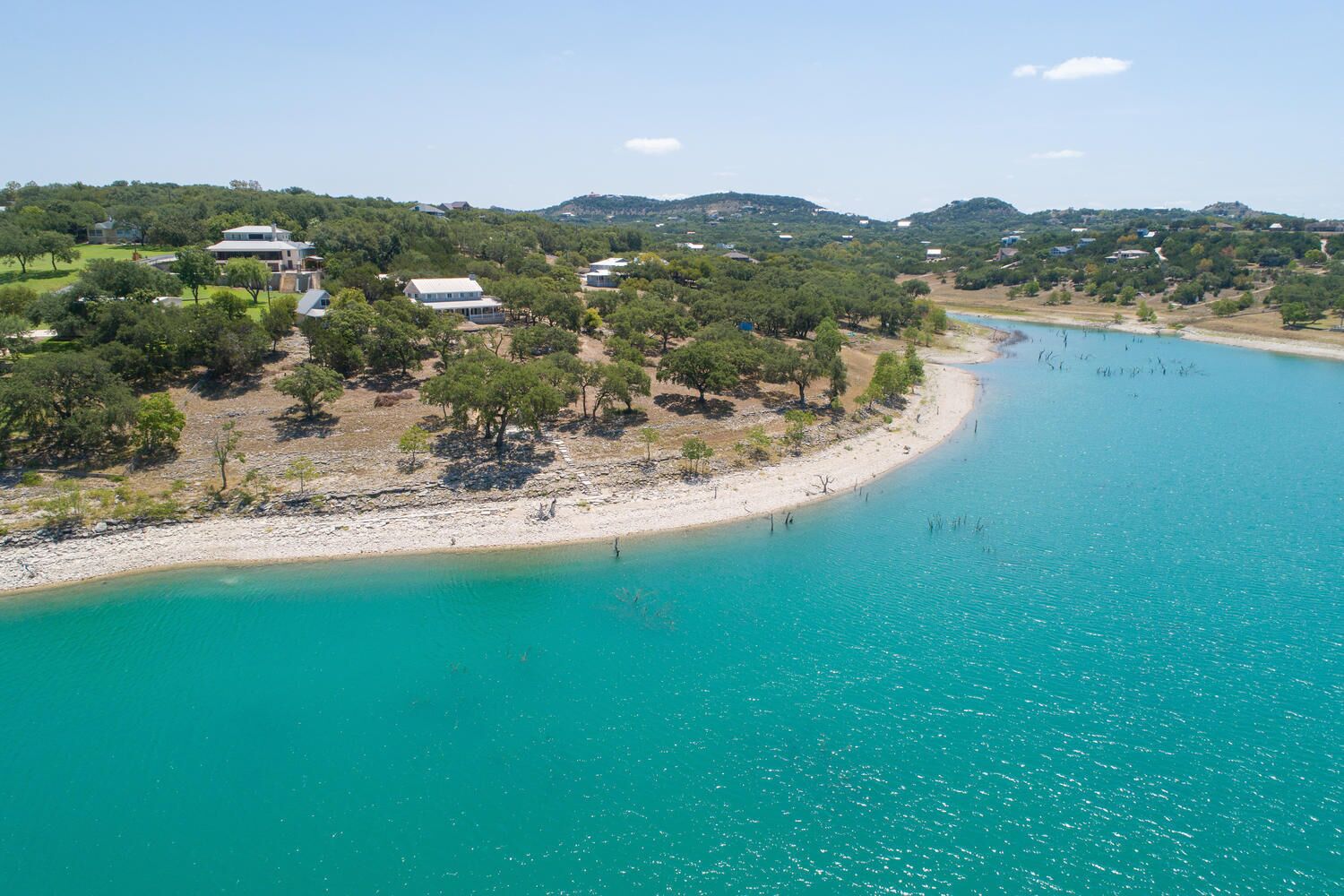 Eine Küstenlandschaft mit Sandstrand und türkisblauem Wasser.
