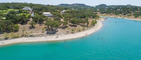 Eine Küstenlandschaft mit Sandstrand und türkisblauem Wasser.