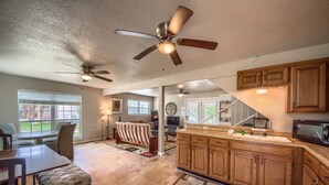 A spacious kitchen with wooden cabinets, a large island, and ceiling fans. - A Shore Thing Cl1105c 1 Bedroom Cottage by RedAwning (Canyon Lake)