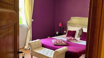 Une chambre à coucher avec un lit, une chaise et une table de chevet.