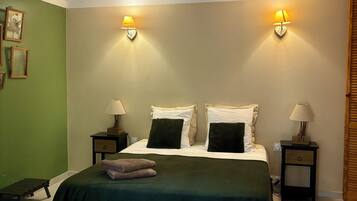 A bedroom with a bed, two bedside tables with lamps, a ceiling fan, and a nightstand with a lamp.