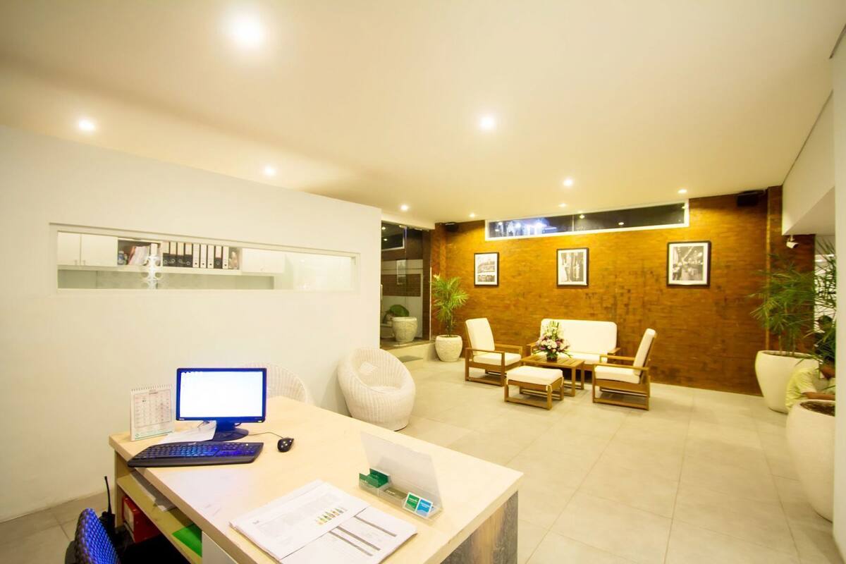 A reception area with a desk, computer, and seating area.