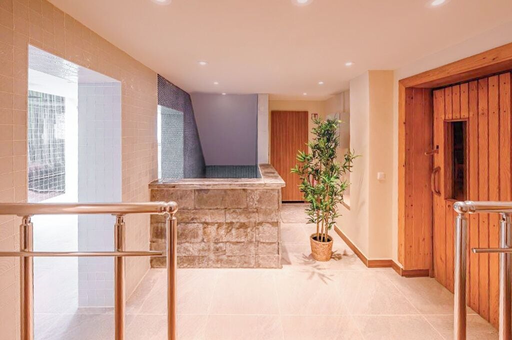 A modern interior with a stone bench, a potted plant, and wooden doors.