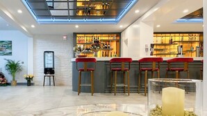 A bar area with a counter, bar stools, and a glass display case with candles. - Sunday Schwarzbachtal Hideaway Resort (Markneukirchen)