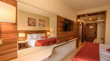 Ein Hotelzimmer mit Bett, Nachttischen, Fernseher und Spiegel.