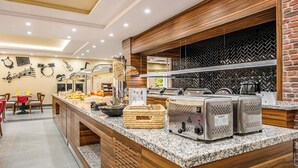 A buffet area with a marble counter, food containers, and a coffee machine. - Sunday Schwarzbachtal Hideaway Resort (Markneukirchen)