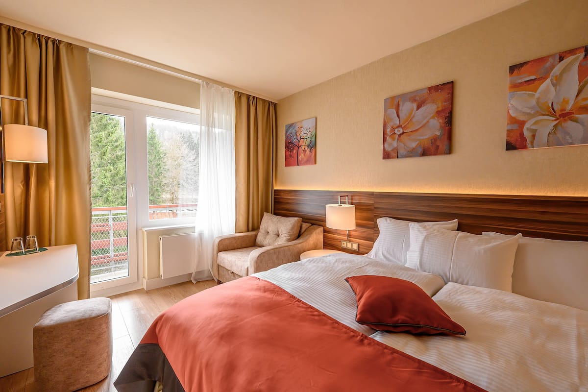 Une chambre d’hôtel équipée d’un lit, d’un bureau, d’une chaise et offrant une vue sur l’extérieur.