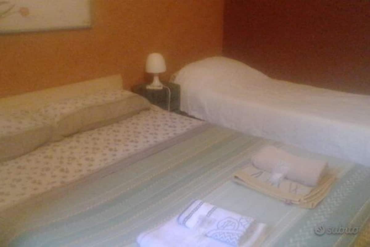 Une chambre d’hôtel avec un lit, une table de chevet et une lampe.