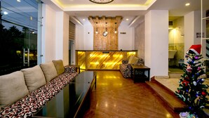 A modern lobby with a reception desk, seating area, and a Christmas tree. - Beautiful Kathmandu Hotel (Kathmandu)