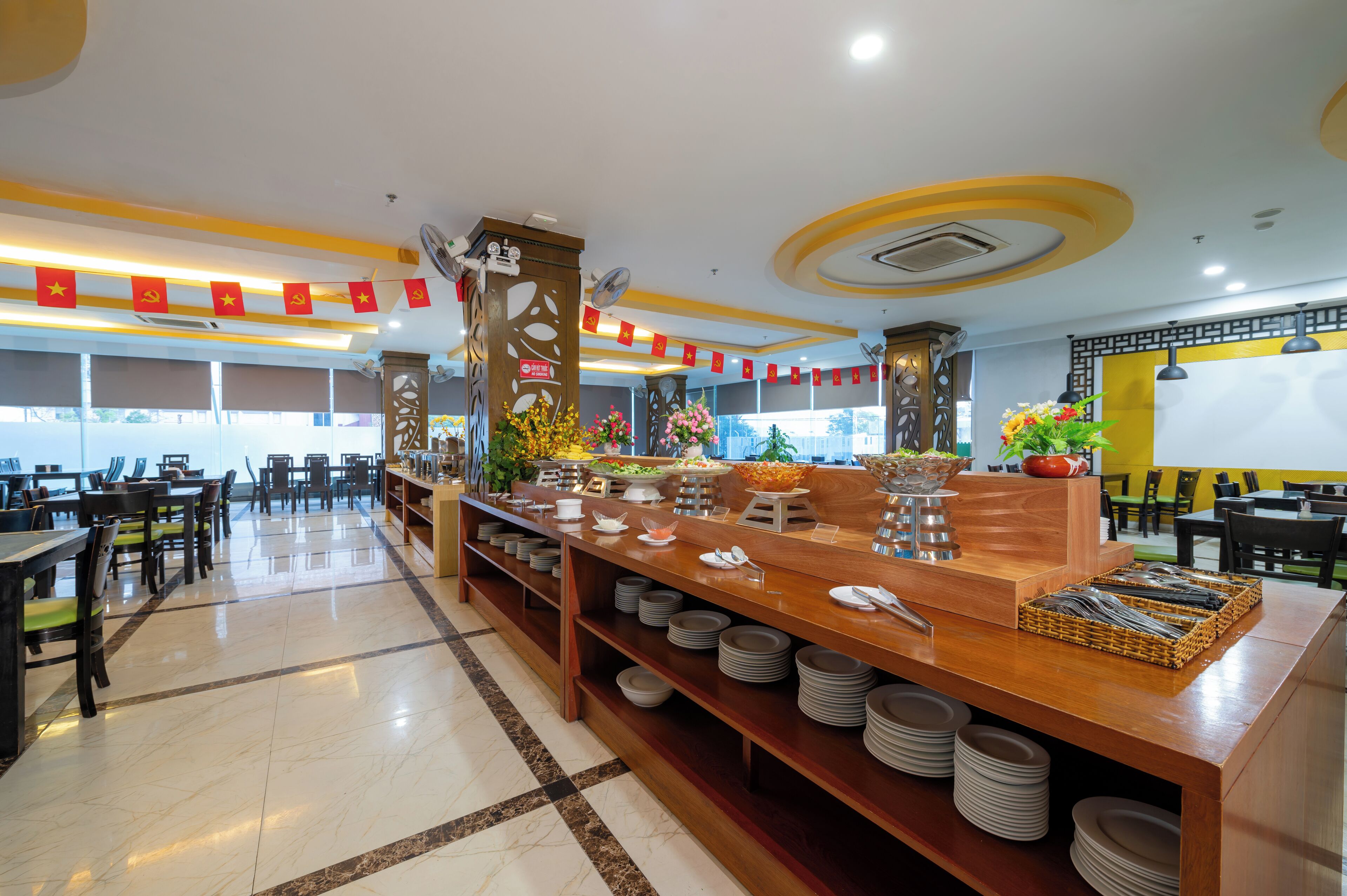 A buffet area with a long counter, multiple seating arrangements, and a variety of food and drink stations.