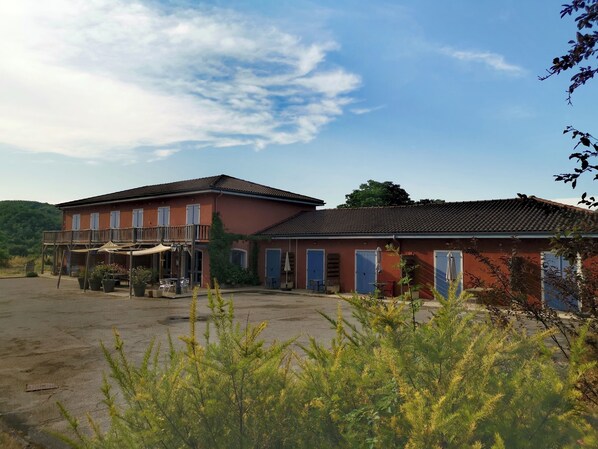 Un edificio de dos pisos con balcón y zona de estar al aire libre.