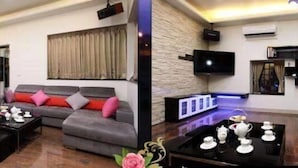 A modern living room with a grey sofa, a coffee table, and a flat-screen TV mounted on the wall. - Annabess (Wujie)