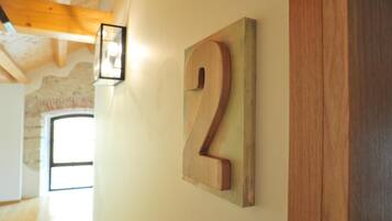 A wooden number '2' sign on a wall, a light fixture, and a wooden beam structure.