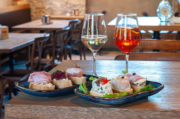 A dining table with two plates of appetizers and two glasses of wine. - Nuova filanda rooms and more (Valdobbiadene)