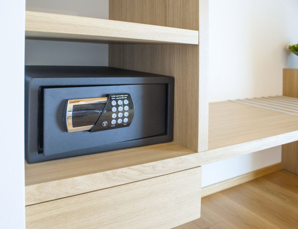 A microwave in a wooden cabinet with a drawer below.