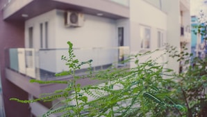A building with balconies and an air conditioning unit. - Homestay Sunny's House (Ho Chi Minh City)