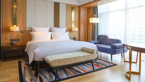 A modern hotel room with a large bed, bedside tables, a desk, and a chair. - Pullman Changbaishan Resort (Baishan)