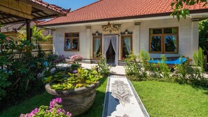 A traditional house with a tiled roof, a welcoming entrance, and a garden with a pathway. - Bali Relax and Comfort (Karangasem)