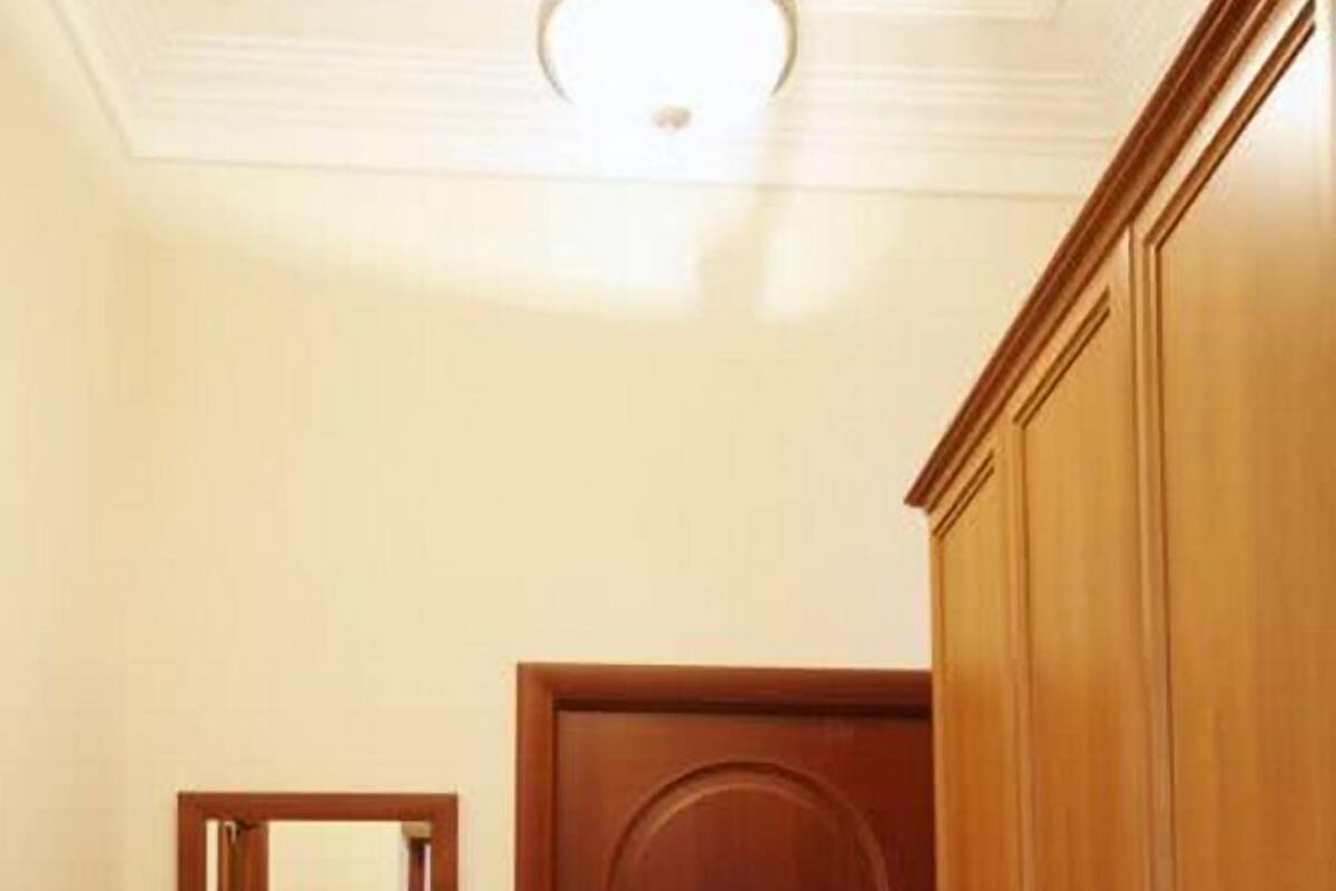 A hallway with a wooden door, a mirror, and a small table.